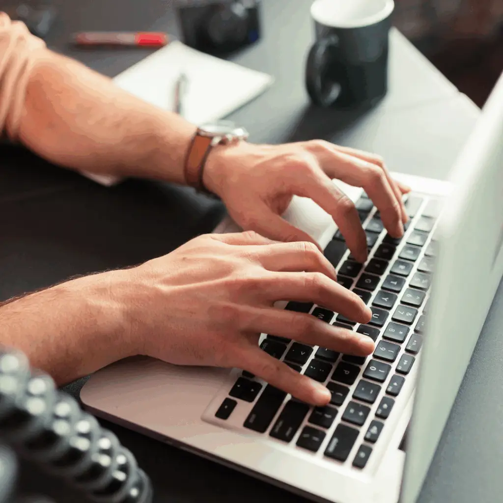 Mãos digitando em um laptop com gráficos e dados coloridos projetados na tela, simbolizando a criação de conteúdo eficaz que gera resultados e conversões. A cena é moderna e iluminada, transmitindo inovação e sucesso no marketing digital.