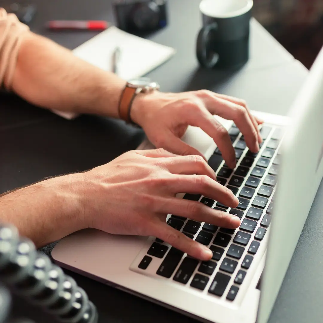 Mãos digitando em um laptop com gráficos e dados coloridos projetados na tela, simbolizando a criação de conteúdo eficaz que gera resultados e conversões. A cena é moderna e iluminada, transmitindo inovação e sucesso no marketing digital.